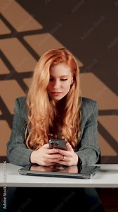 A female freelancer talks on the phone and video call at work. Call center worker. Online work concept. Vertical video