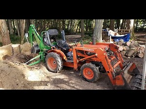 Kubota B7100 Digging Out A Tree Stump With A Bradco 3265 Backhoe.
