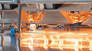 Close-up shot of a large-scale machine for the packaging of metal sheets in the process of panel production. Slow motion