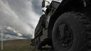 Dollying time-lapse of a stationary military convoy truck.