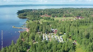 Camping ground by lake in forest. Camp sight in aerial drone shot. Trailer or caravan park area for mobile homes and travel trailers, Sweden