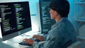 Software developer using keyboard debugging code programming task monitor screen system application development focus logic