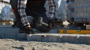 Worker Installing Interlocking Paving Stones