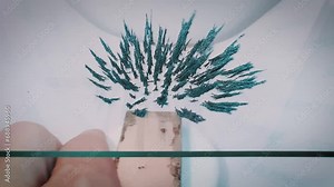 Iron filings moving in the magnetic field of a neodymium magnet, angle shot.