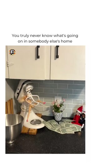 Busted Tees on Instagram: "Forget Elf on a shelf. It's ---- Follow @bustedtees for more! This viral Elf on the Shelf parody video takes holiday mischief to a whole new level with a chaotic Barbie doll setup on a kitchen countertop. In this funny Christmas meme, Barbie is hilariously tangled in an automatic hand mixer while an Elf on the Shelf figure, surrounded by fake money scattered across the counter. The over-the-top scene feels like a wild holiday prank gone wrong, blending dark humor, absu