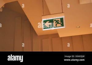 An illuminated exit sign points left, showing a clear path to safety.