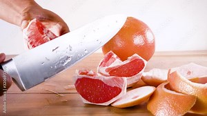 removing seeds from grapefruit segment with the tip of a knife