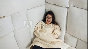 A crazy asian woman in a straight jacket at a mental asylum in a padded cell.