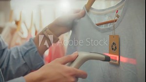 An Asian store scanning specialist uses the latest technology, using a red beam laser scanner to scan barcodes. The manager of a designer clothing shopping center keeps track of goods