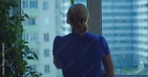 Window cleaning. House cleaning. A blonde woman washes the inside of a window with a special mop with a sponge on a sunny day