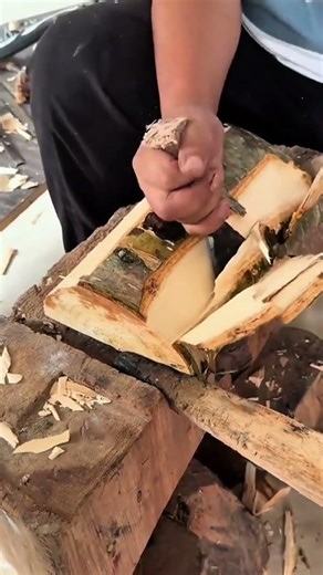 smoothing the edge of a thick wooden board using a manual hand plane tool on a sturdy work table