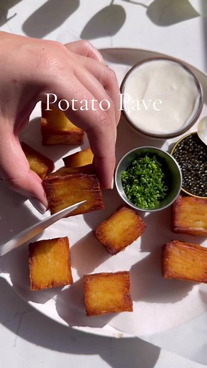 Potato Pavé 🫶🏻 these are high maintenance but boy are they worth it ❤️. Tbh you can eat them plain with a bit of salt and they are bomb! I just made them a bit extra 😉. Ingredients: * 4 large russet potatoes or 6 medium ones. * 1 1/4 cup cream. * seasoned salt to taste. * 5 tbsp butter. * olive oil for frying. * chives to taste. * creme fraiche to taste. * caviar to taste. Directions: 1. Wash and peel your potatoes. 2. Add the cream to a bowl with seasoned salt and mandoline the potatoes into