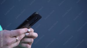 The woman's hands are holding a smartphone and fingers are typing text on touch screen for authentication, internet banking or buying goods remotely. Scrolling social media newsfeed.