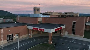 Hospital Ambulance emergency entrance and sign. American healthcare system and medical care theme in USA. Heliport pad sign. Rising aerial.