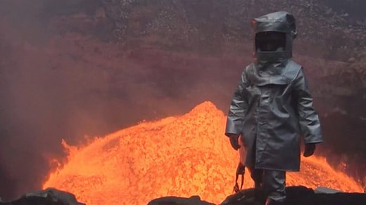 Man walks into crater of an active volcano - video