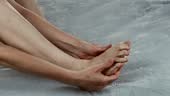 Woman massages her toes using a moisturizer. Revitalizing foot...