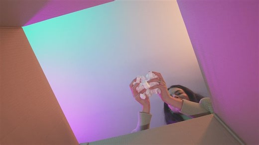 Smiling girl putting packing filler in a box - Free Stock Video