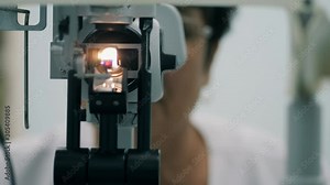 Female ophthalmologist working with medical device at clinic.