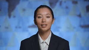 Portrait of a young beautiful woman presenter in a suit looks at the camera, tells the news, hosts the program