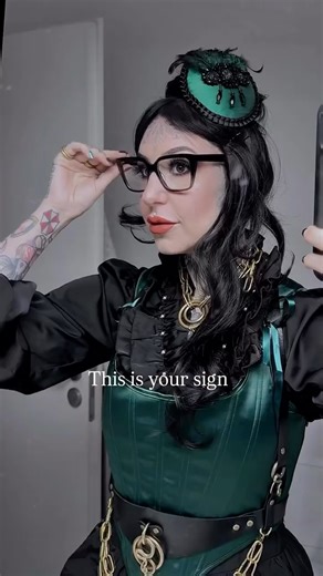 Sara Vayne | Alt Fashion | Outfit Inspo on Instagram: "DO IT! Grünes Korsage mit Struktur als Fokus. Schwarze Bluse mit Perlendetails darunter. Kleiner grüner Fascinator als Akzent, passend zur Korsage! Goldfarbener Schmuck und Accessoires für Kontrast. —- outfit inspo | dark formal outfit | corsage outfit | layered outfit | statement accessories | personal style | self expression | outfit confidence | wear what you want | empowerment through style #outfitinspo #darkstyle #selfexpression #outfit