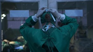 Portrait of a female surgeon getting ready wearing a mask in a hospital operating room.