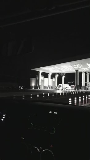 Nighttime Gas Station Scene with Illuminated Vehicles