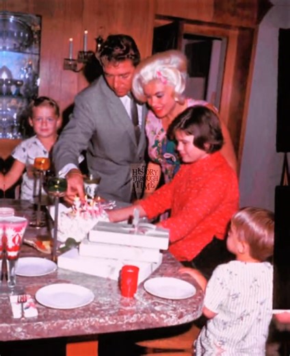 "Circa November 1963, Jayne Mansfield and her second husband, Mickey Hargitay, were photographed beaming with family pride during a private celebration at their opulent Beverly Hills estate, famously known as the Pink Palace. The occasion marked the thirteenth birthday of Jayne’s daughter, Jayne Marie Mansfield, from her first marriage to Paul Mansfield. Surrounded by their two young sons—Mickey Jr. and Zoltan—the family gathered in the heart of the home, beneath chandeliers and among heart-shap