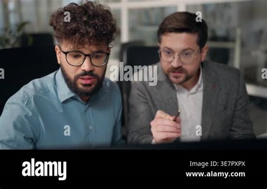 Two concentrated multiracial businessmen looking in computer screen monitor talking diversity business men working talk Arabian and Caucasian males assistance work corporate project using software Stock Video Footage - Alamy