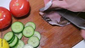 Preparation of Atlantic herring fillets. The cook removes bones using special forceps. Quality checking.