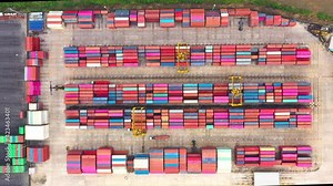 Aerial top view over international containers cargo industrial import-export port yard prepare to load containers with big container loader ship vessel. global transportation and logistic business.