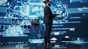 Male business person studies artificial intelligence strategy and automation tools. Surrounded by data visualization, neural networks and cloud computing, he explores smart technology. Camera B.