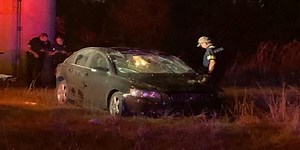 Driver flips car, lands on train tracks