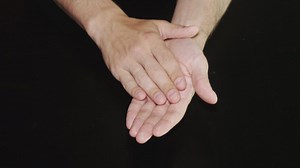 Hands clapping against a dark background - Free Stock Video