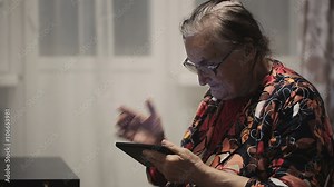 Lonely grandmother using tablet computer, she wrote a letter to his son