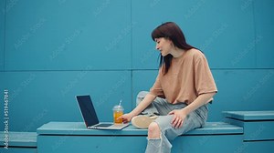 Woman working on laptop outdoor. Female student typing on keyboard computer close-up, freelancer drinking lemonade. Remote work, business. Communicating with family and friends online.