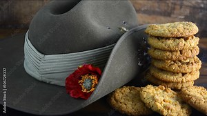 Anzac Day Australian army slouch hat with traditional Anzac biscuits close up, placing the last biscuit.