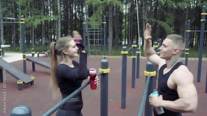 Athletic couple giving high five after finishing their training.