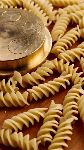 Eduardo Pasinelli on Instagram: "⬇️ Making Fusilli with a pasta extruder. 📕 Advantages: 1. The bronze die gives the pasta a rough texture, ideal for holding more sauce. 2. These machines allow you to make pasta shapes that are not possible to make manually. 3. The pasta extrusion process gives the pasta uniformity and consistency. 4. Speed of pasta production. 🔔 Secret tips: • Use high quality semolina for better extrusion and color. • Chill the die slightly before use - it helps the pasta rel