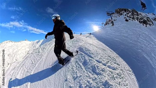 Professional snowboarder carving down a steep, sunny mountain slope on a beautiful winter day, enjoying an extreme sport adventure with a scenic alpine background and chairlift view