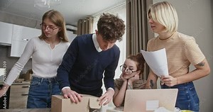 Young Team Evaluating Cardboard Packaging Design in Collaborative Workspace Stock Video
