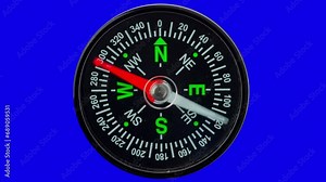 Modern magnetic compass on a blue isolated background with a red arrow defining the direction.