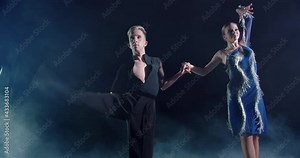 Man and woman dance ballroom dance on stage. The guy is dressed in black and the girl is in blue. They make complex elements and supports. They show their stretch and flexibility