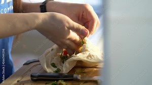 Cooking a vegetarian meal at home fulling a pita bread with many vegetables.