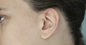 Female human ear and hair concept. Cosmetic skin care procedure