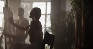 Female artist working during life drawing session in home studio