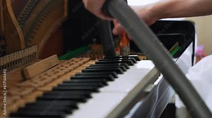 The scene of professional services piano cleaning piano keys by vacuum and brush off dust inside the piano, skilled profession, musician maintenance.
