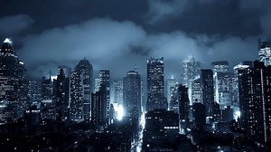 Cityscape showcased at night, revealing a stunning skyline under dramatic clouds and lights