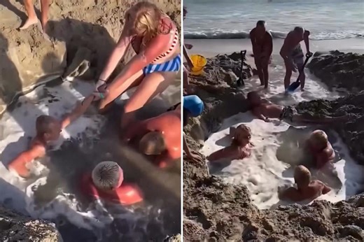 Horrifying video shows frantic beachgoers scramble to save boys trapped in sand hole after it fills with water