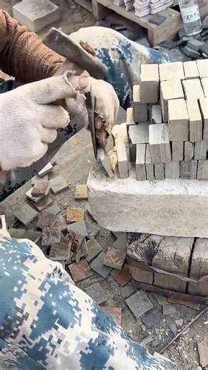 shaping small stone tiles with hammer and chisel for traditional masonry construction projects