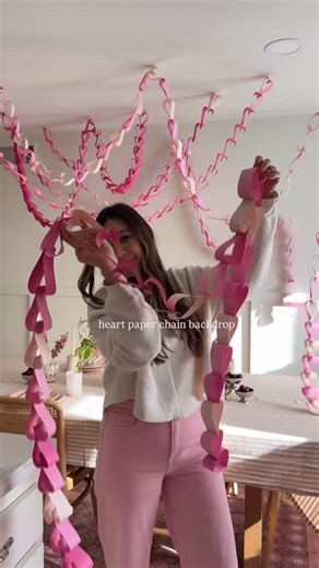 Deborah Trette on Instagram: "heart paper chains as the main character this galentine’s!! make a few and hang them for a cuuuute party backdrop/centerpiece 🫶🏻 I used 65lbs cardstock paper (@michaelsstores had the perfect pack!) cut into strips, stapled together in the shape of a heart and hung using mini command hooks and fishing line! you can also use packing tape as it can hold the non floating ones. For links, comment HEART https://liketk.it/5P3Kr"